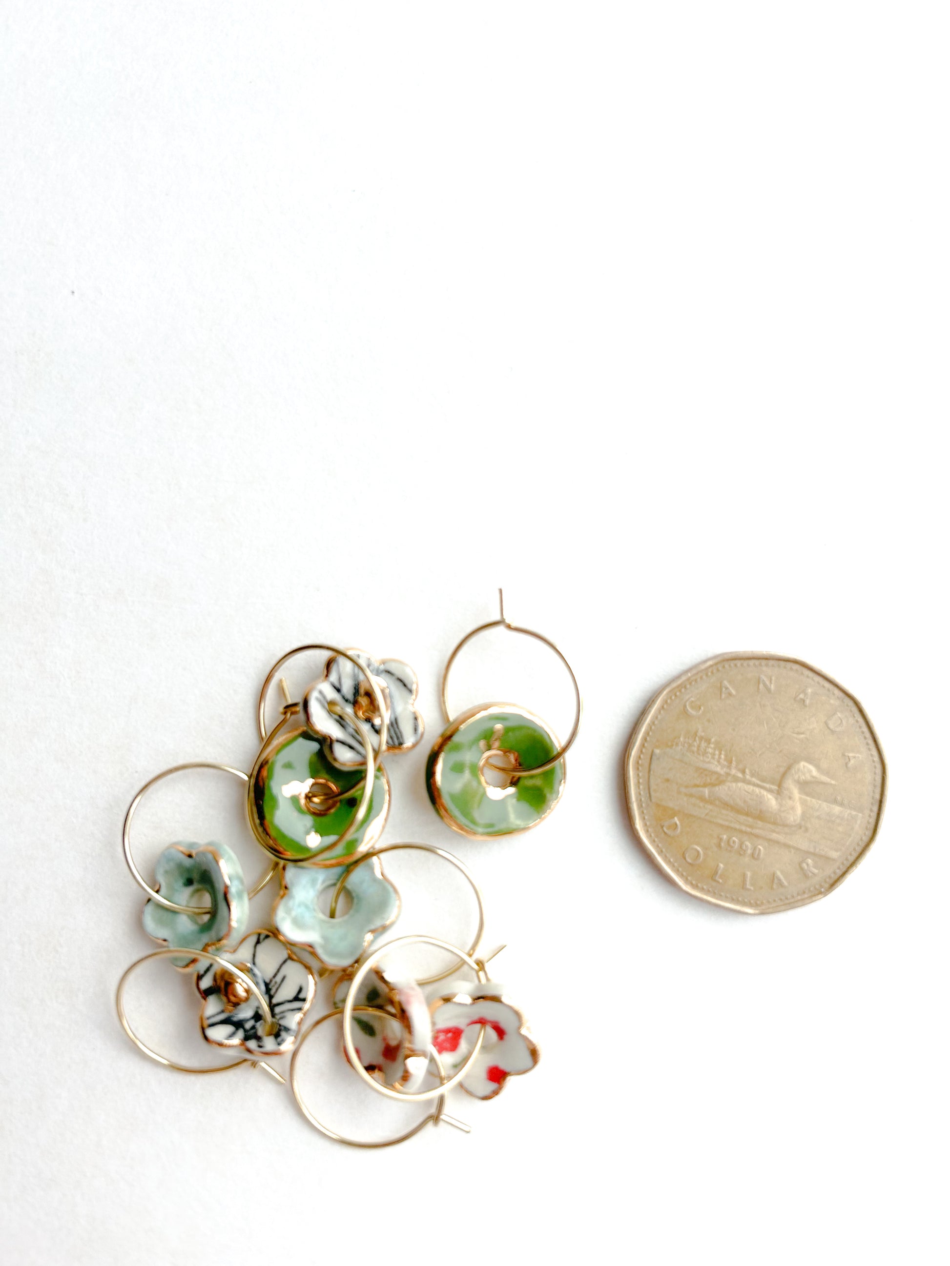 Set of floral earrings with a penny for scale on a white background